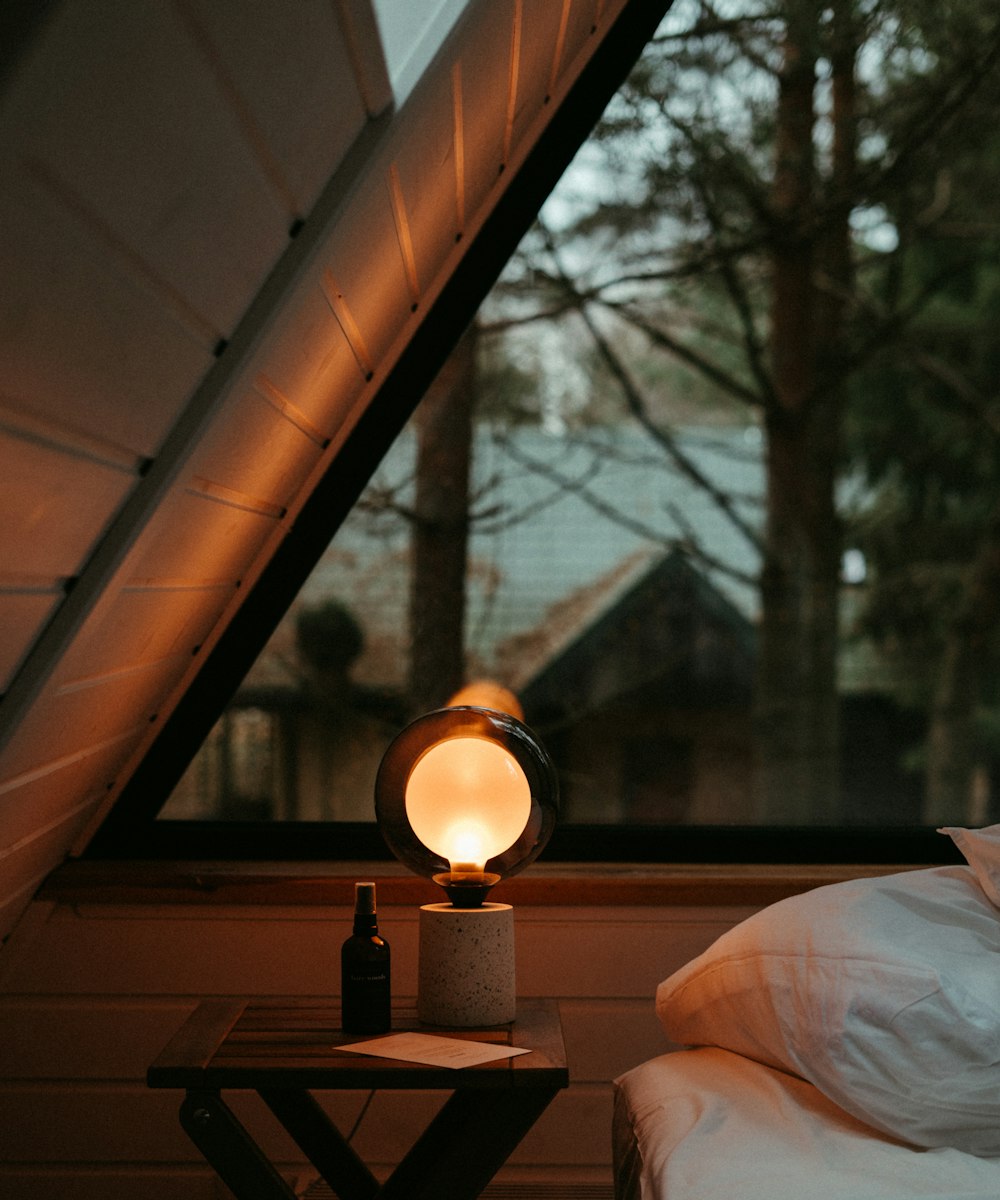 A warm, furnished rental room interior with a made bed beside a window